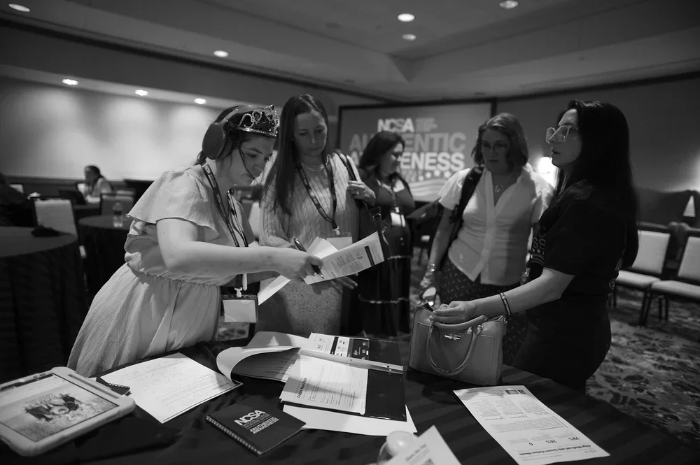Jadyne helps hand out materials to arriving guests.