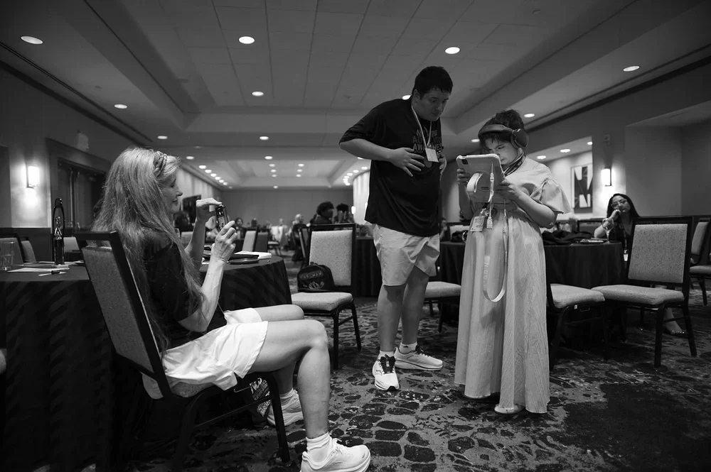 Luke leans in to share what Jadyne is watching as Christine photographs them.