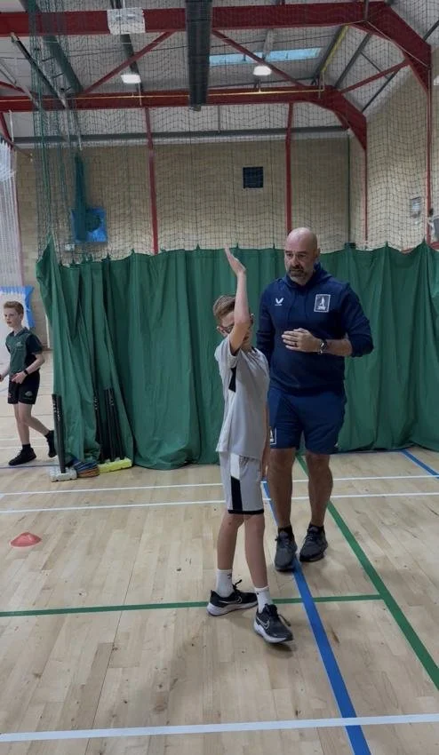 Jono helping a young cricketer practise their bowling arm position