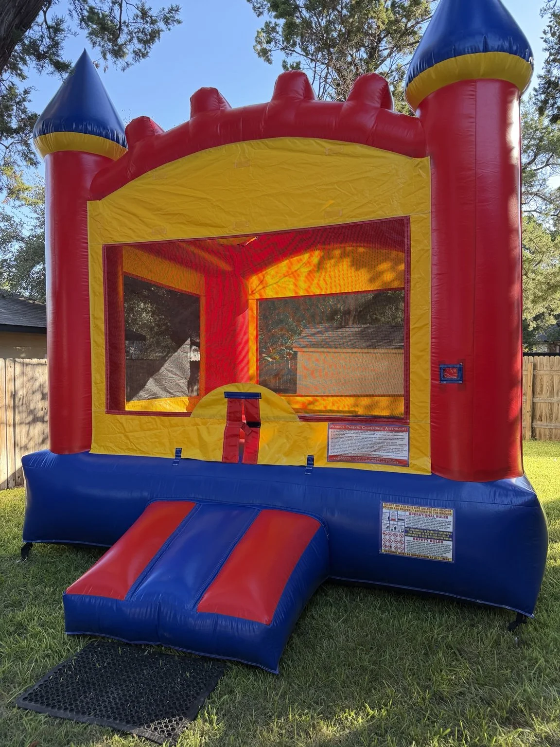 Red, yellow and blue Castle Bounce House set up outdoors by Hill Country Celebration Rentals