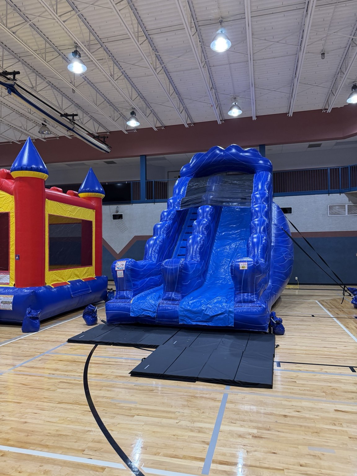 Tidal Wave water slide and Castle Bounce House at an indoor HCCR setup.