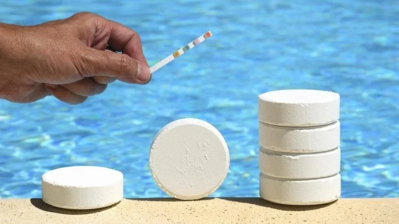 sunlit residential swimming pool with chlorine test kit