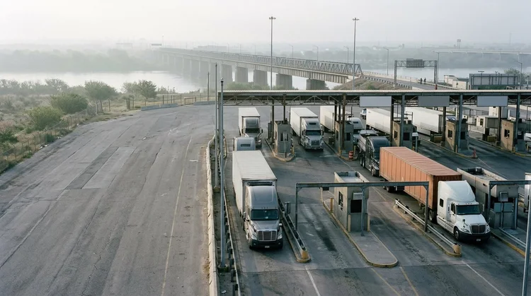 Freight trucks queue at a commercial border crossing