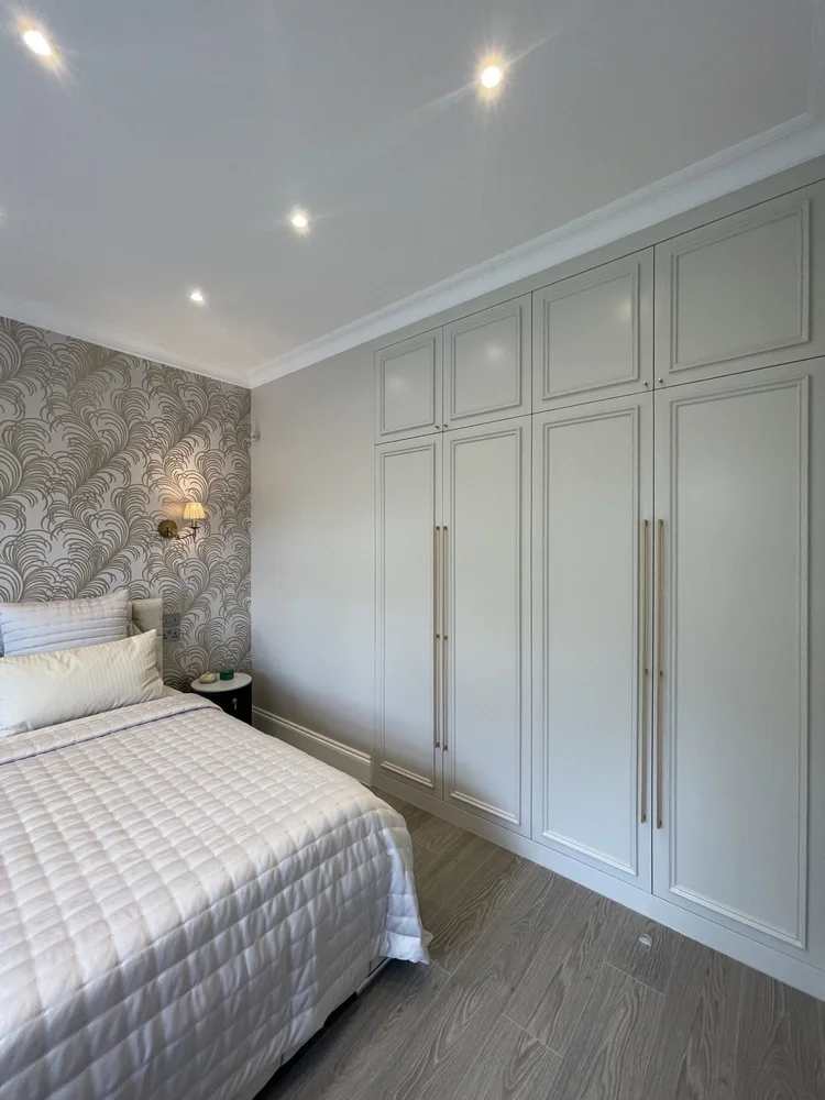 Bespoke panelled wardrobes with long brass handles