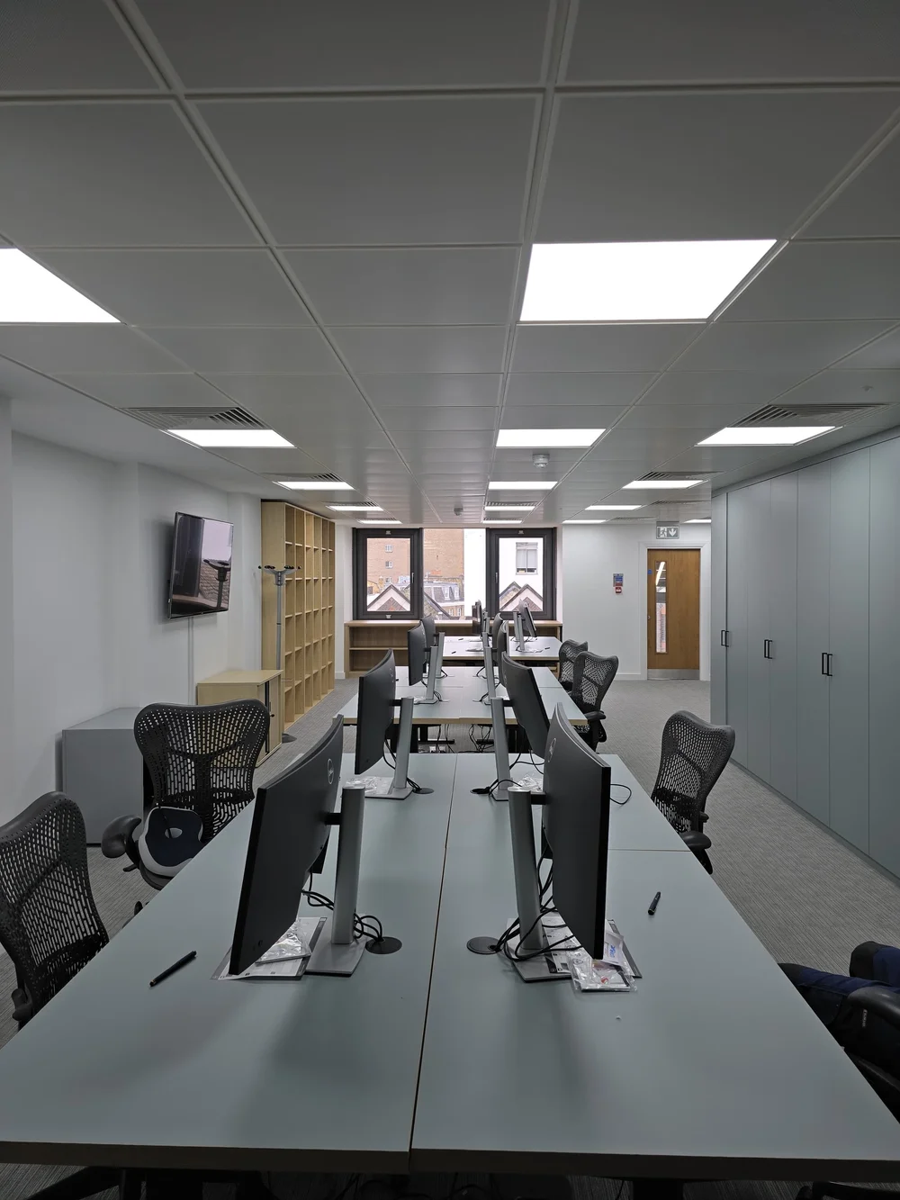 Open-plan office with desks and built-in cupboards in a Knightsbridge office fit-out by RELM Interiors