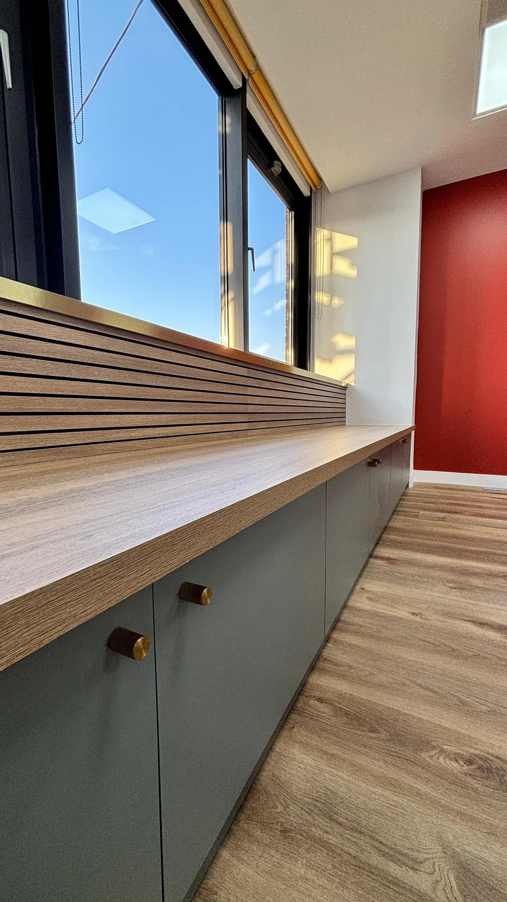 Bespoke window bench with slatted back and brass knobs in a Knightsbridge office by RELM Interiors