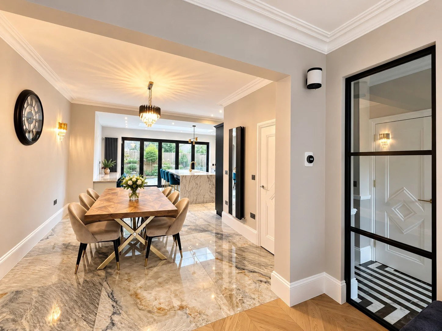 Dining room with marble floor opening onto a kitchen extension with bifold doors in Wimbledon, by RELM Interiors
