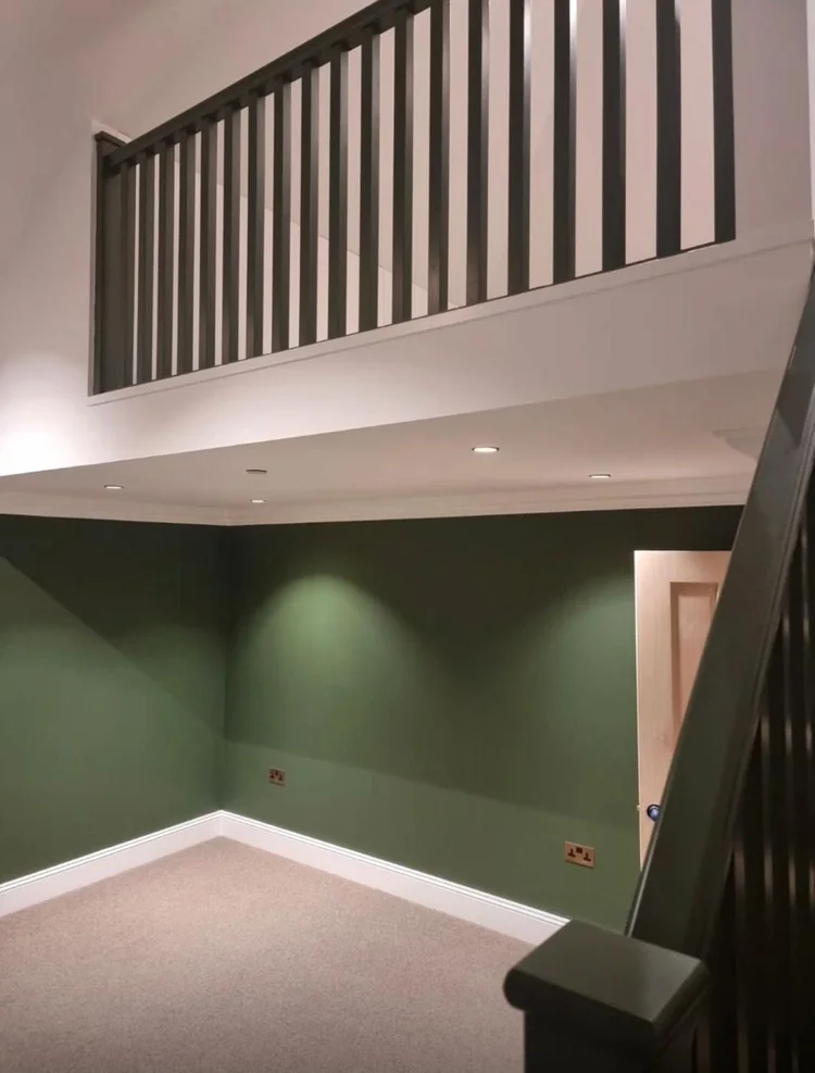 Mezzanine with a painted green balustrade in a Victorian cottage in SW19 renovated by RELM Interiors