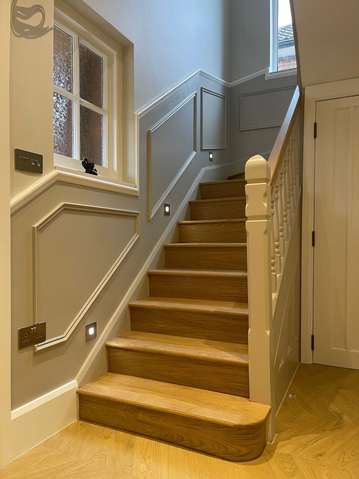 Reconfigured staircase and panelled hallway in a four-storey house renovation in Morden by RELM Interiors