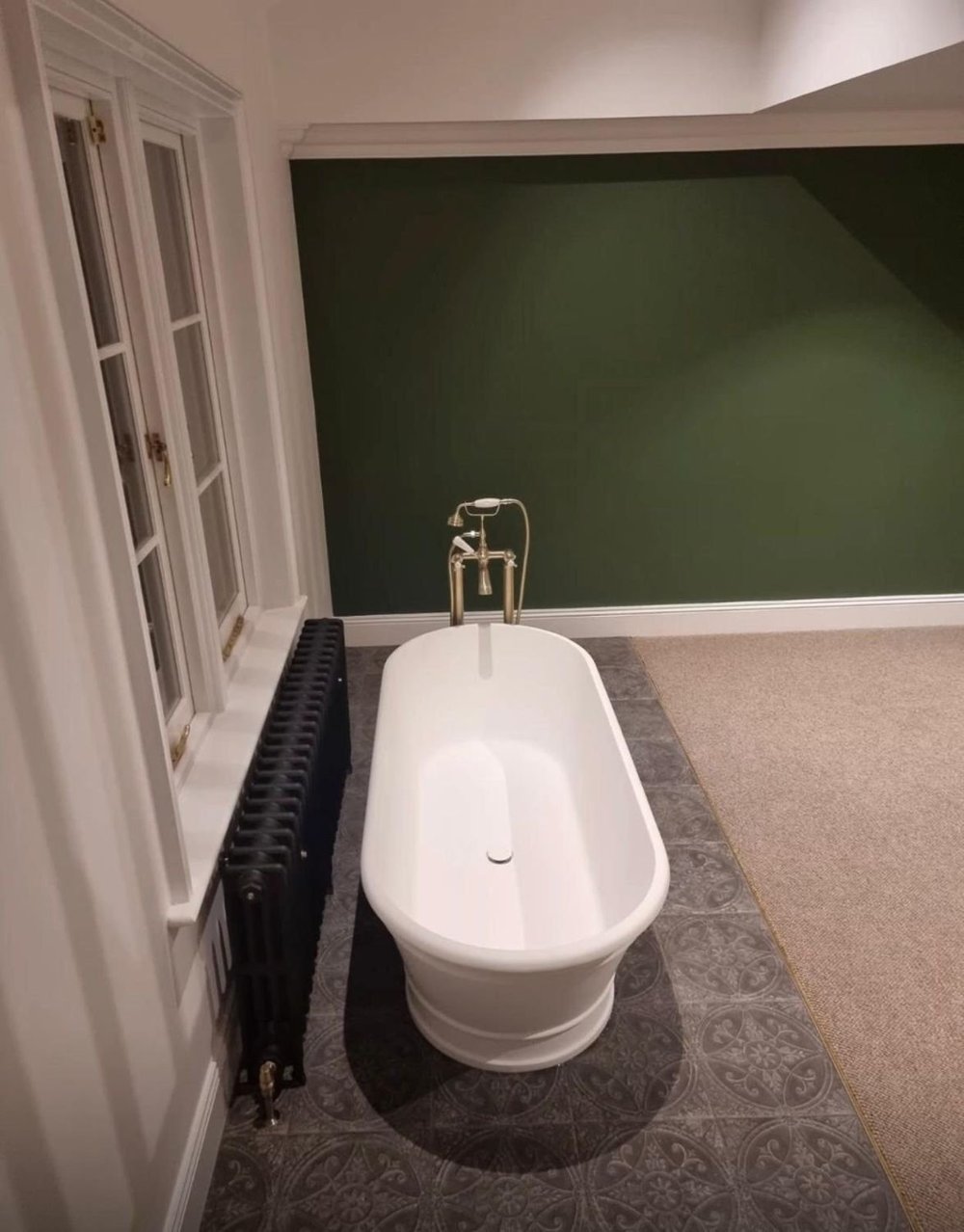 Freestanding bath with a brass mixer on a patterned tiled floor in a Victorian cottage in SW19 renovated by RELM Interiors