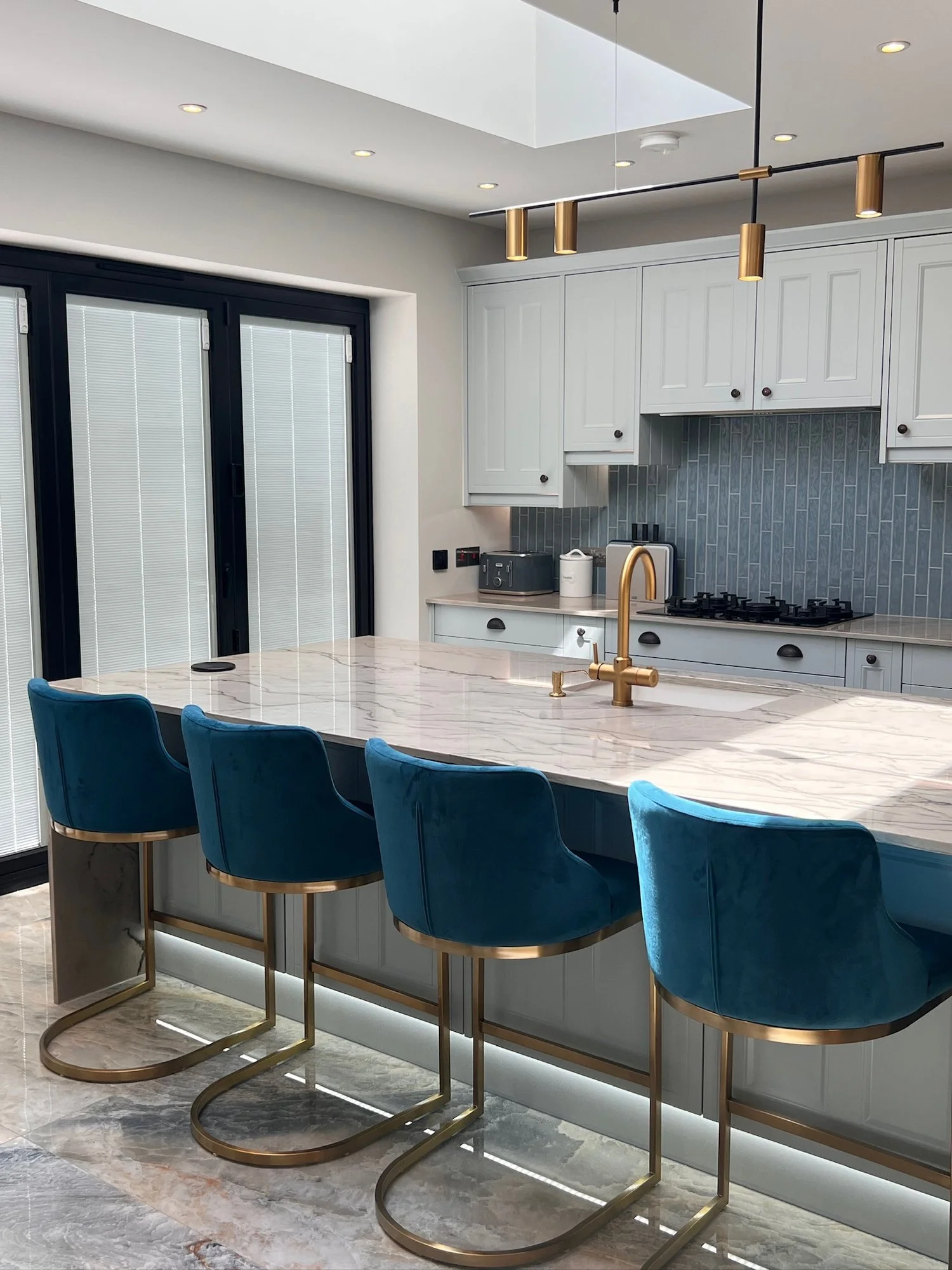 Waterfall-edge kitchen island with stools in a Wimbledon house renovation by RELM Interiors