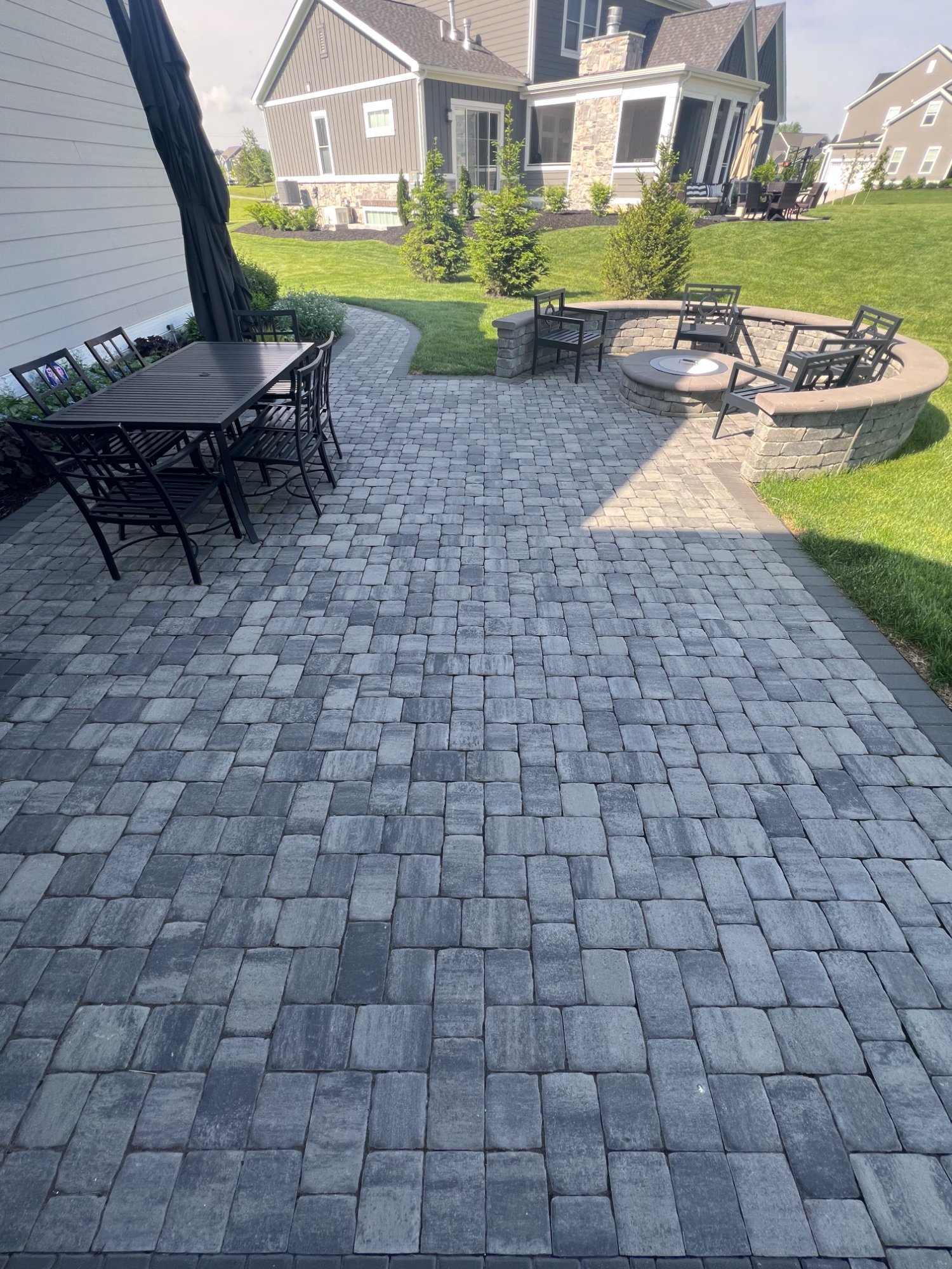 Large paver patio with fire pit seating area and outdoor dining