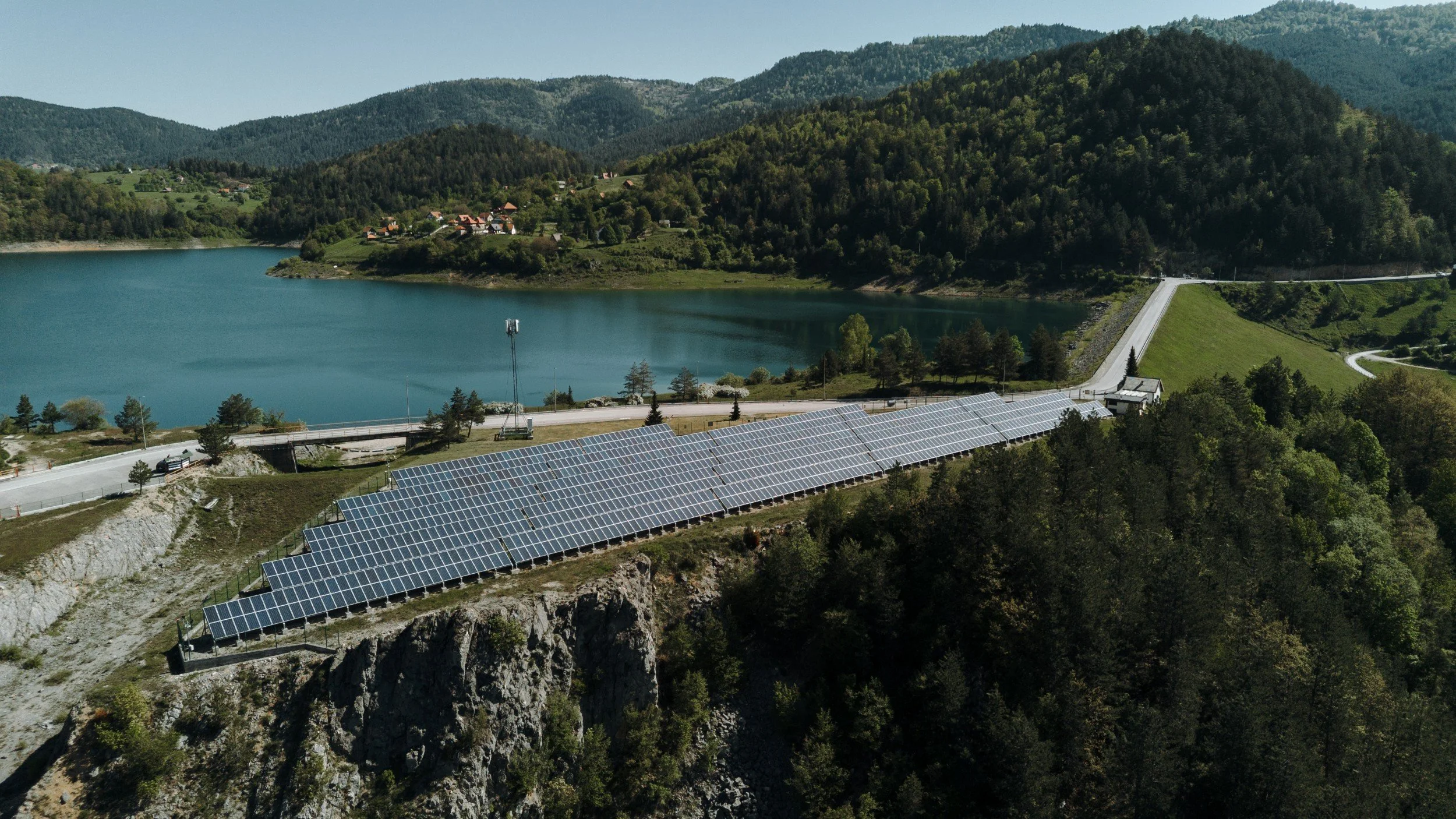 Solar PV array beside a reservoir in the Balkans — sustainability reporting and ESG disclosure for energy projects