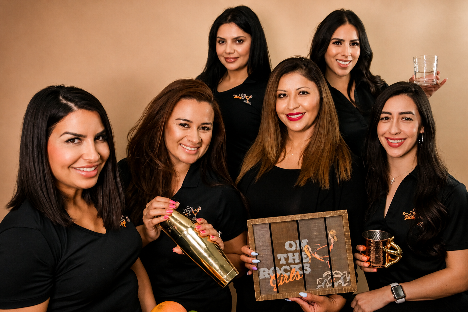 The On The Rocks Girls mobile bartending team, six professional bartenders in branded black polos holding shakers and copper mugs