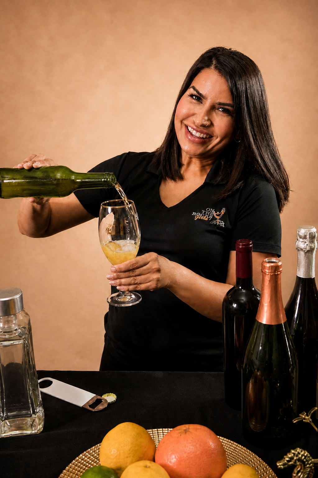 Gaby of On The Rocks Girls in a branded OTR polo pouring sparkling wine into a glass at a styled event bar
