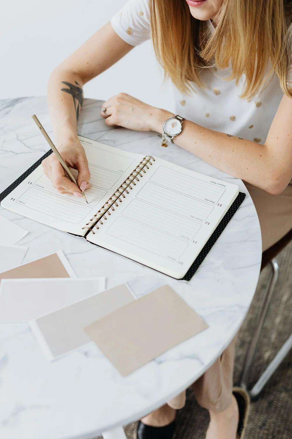 Event planner writing in planning notebook with samples