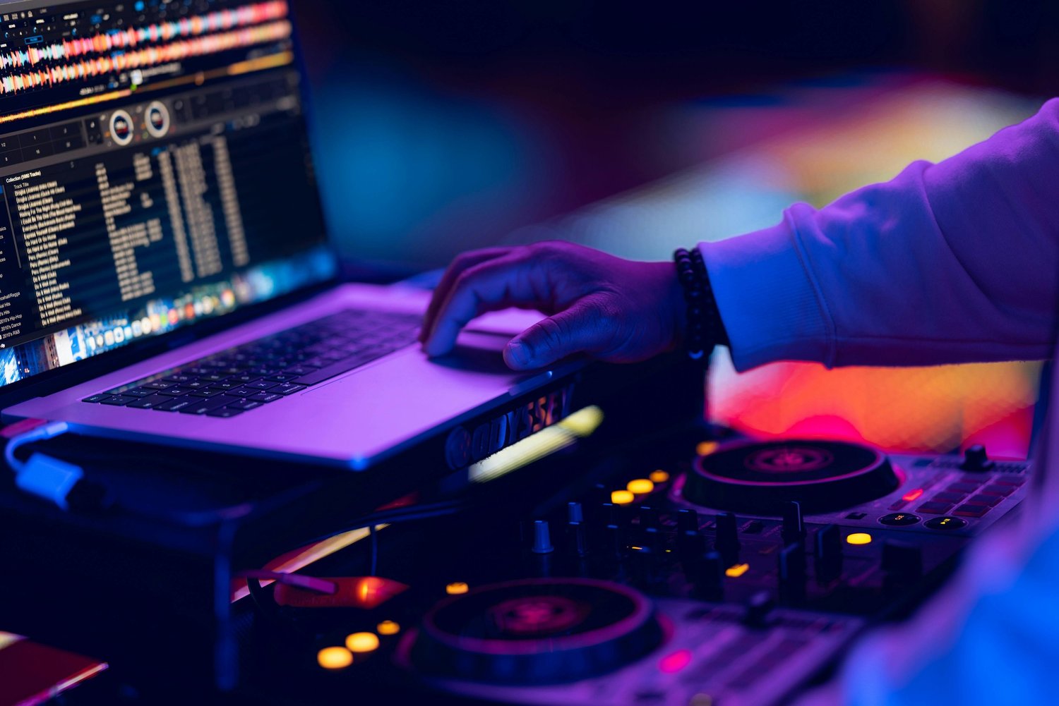 Wedding DJ mixing music at reception, illustrative