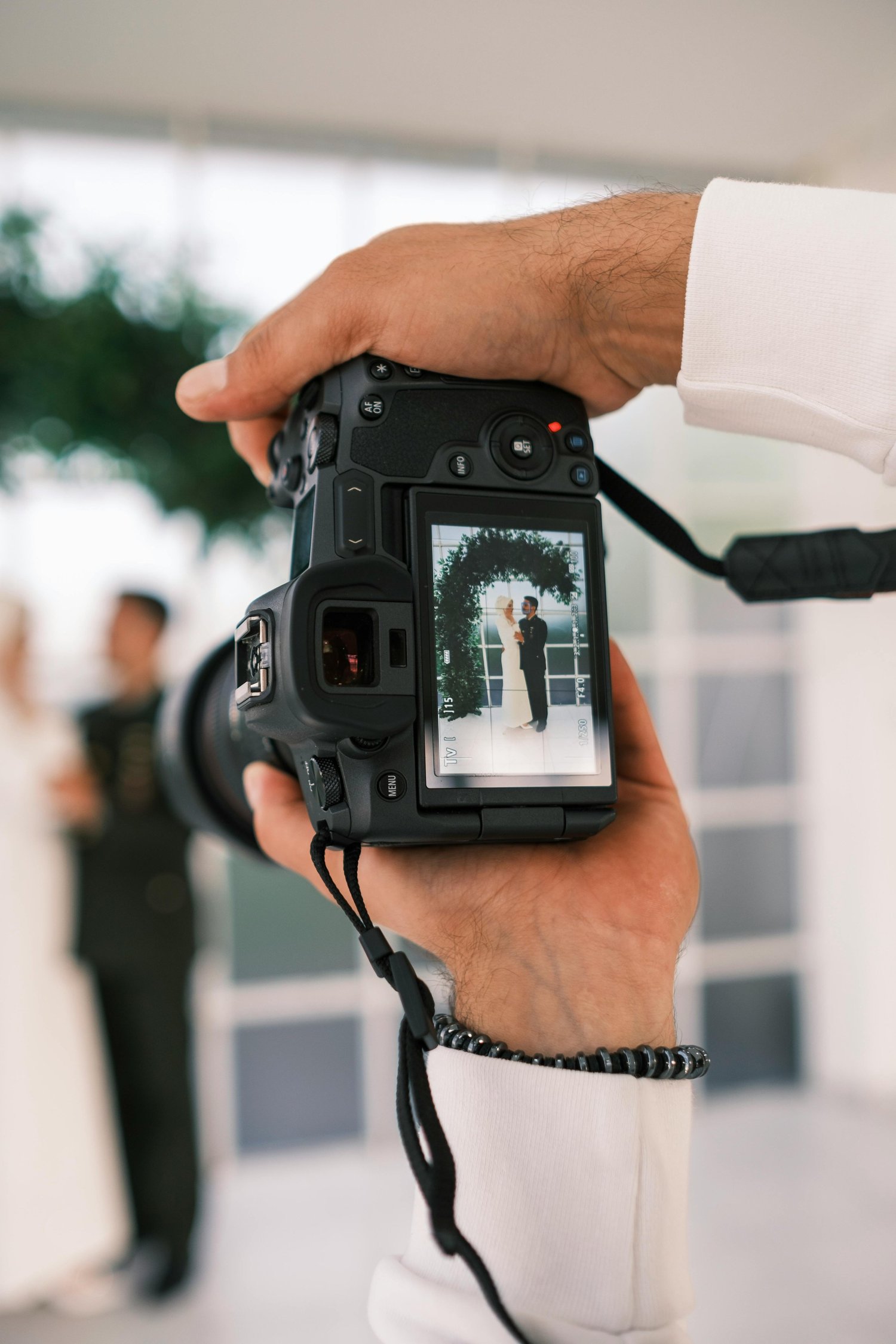 Wedding photographer with camera capturing couple, illustrative