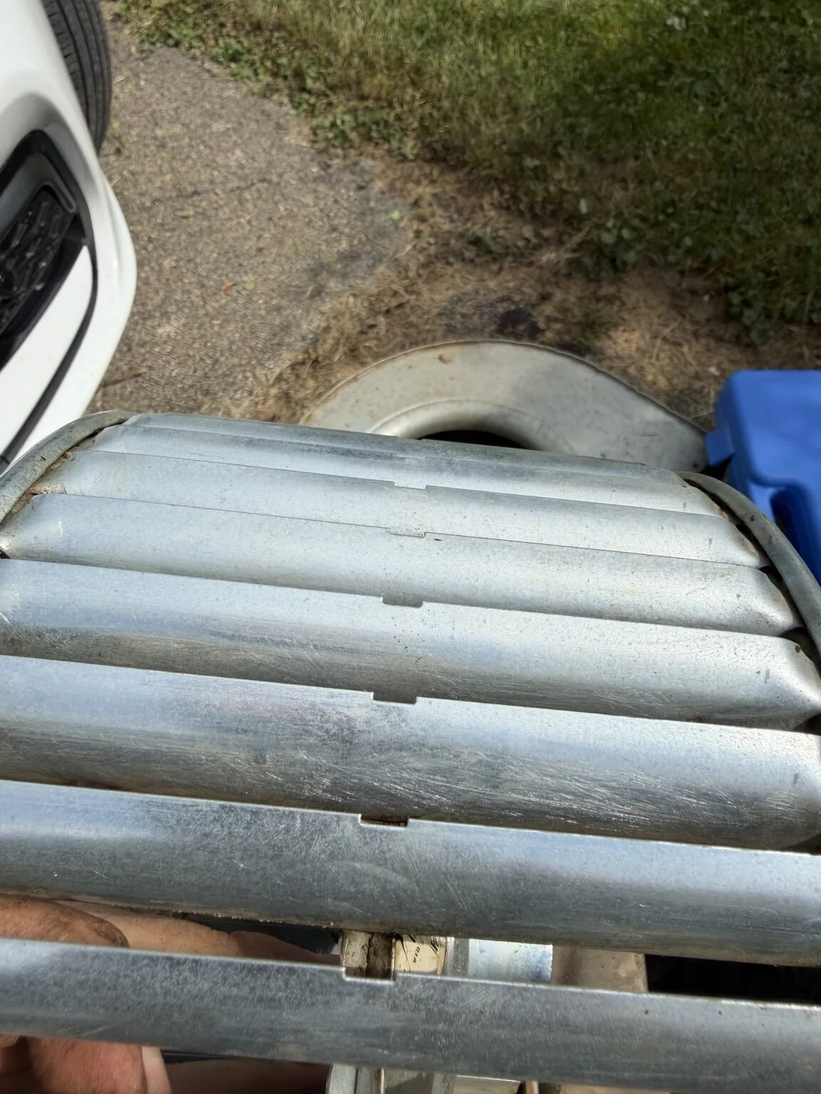 The blower wheel held outdoors after cleaning, with the metal blade surfaces exposed.