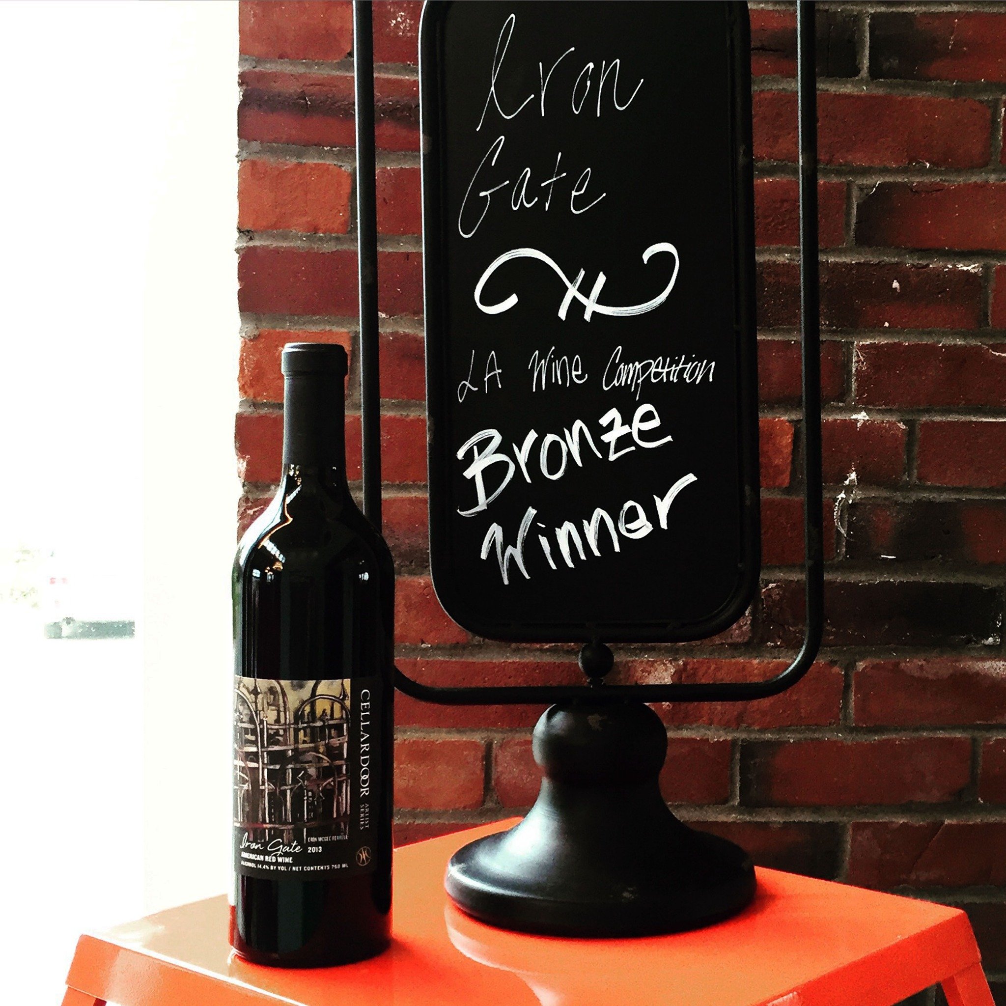 Iron Gate wine bottle with Erin McGee Ferrell’s label beside a Cellardoor wine competition display