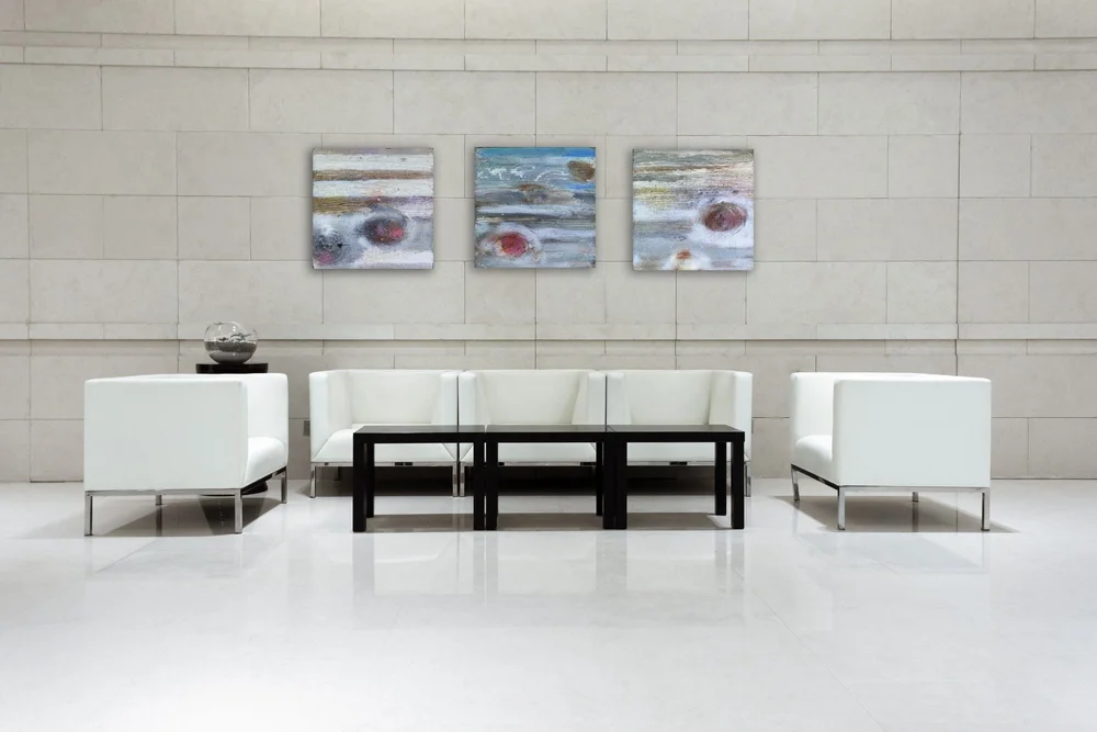 Room visualization showing three Jupiter paintings above a white sofa