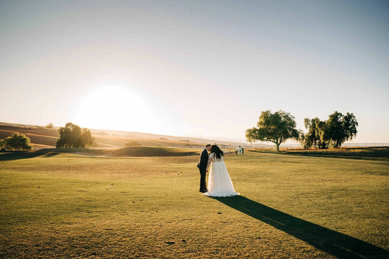 Alicia and James walking through Poppy Ridge Golf Course at sunset