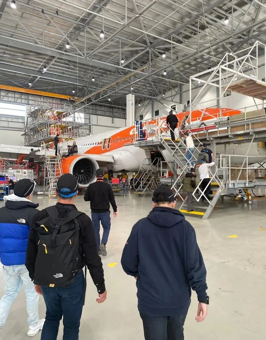 VET students participating in work-based learning inside an aircraft maintenance hangar.