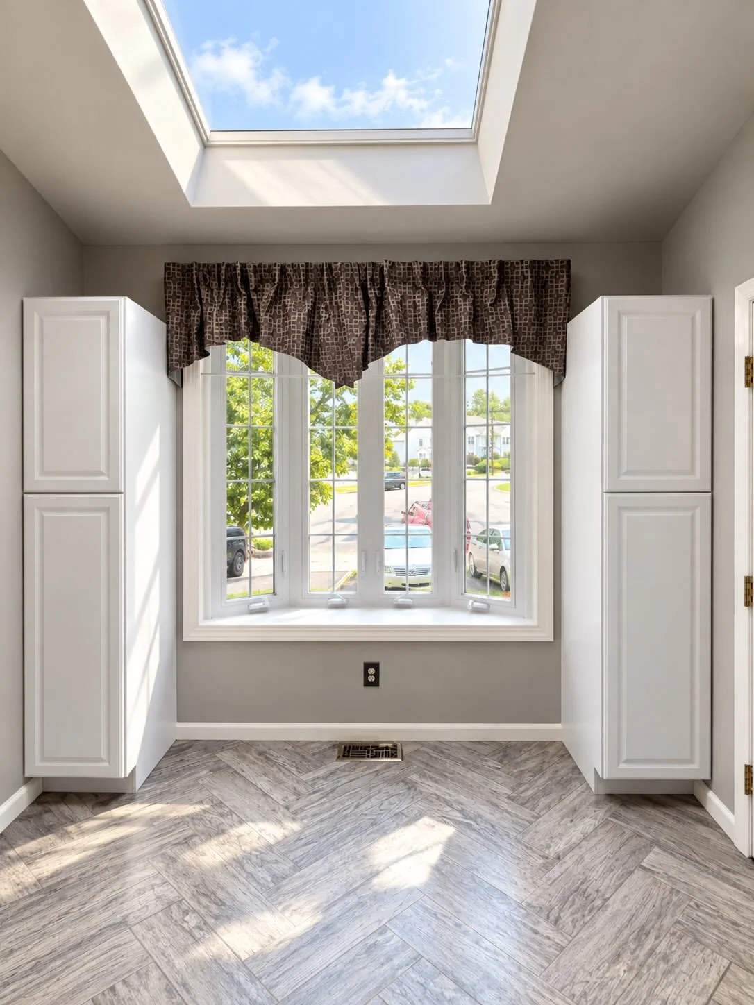 Finished interior with bay window, skylight, trim, and fitted cabinetry