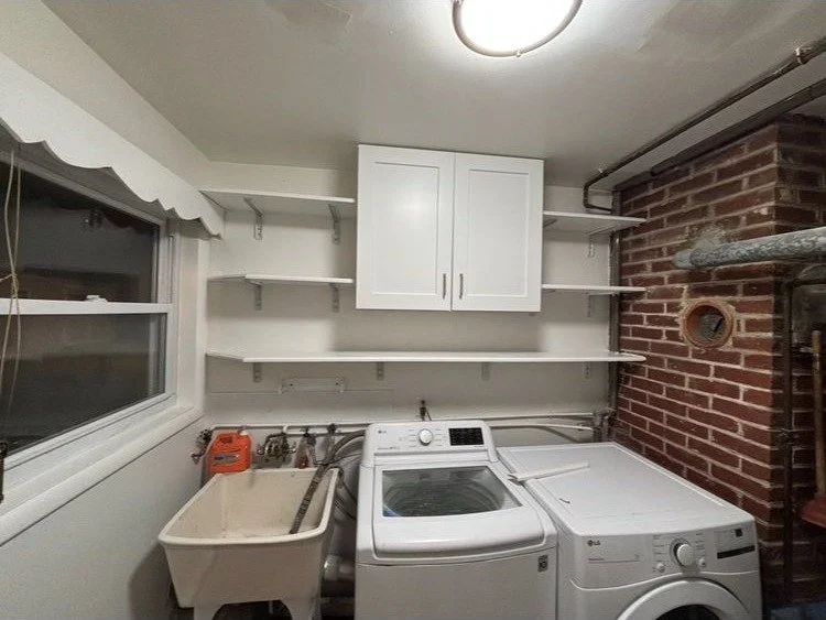 Renovated laundry room with custom white cabinets and shelving in Montgomery County PA