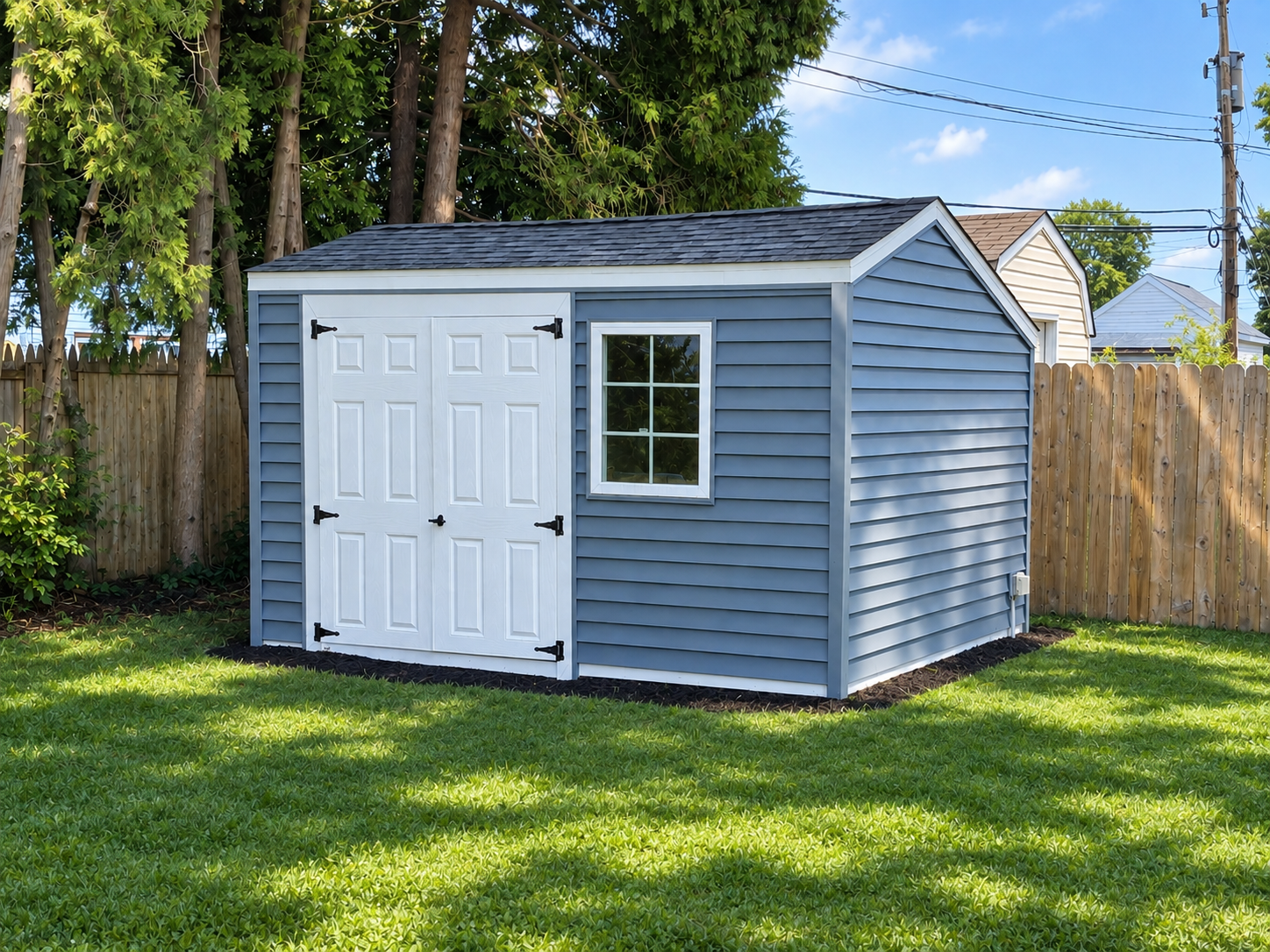 Completed blue backyard storage shed with white double doors and window