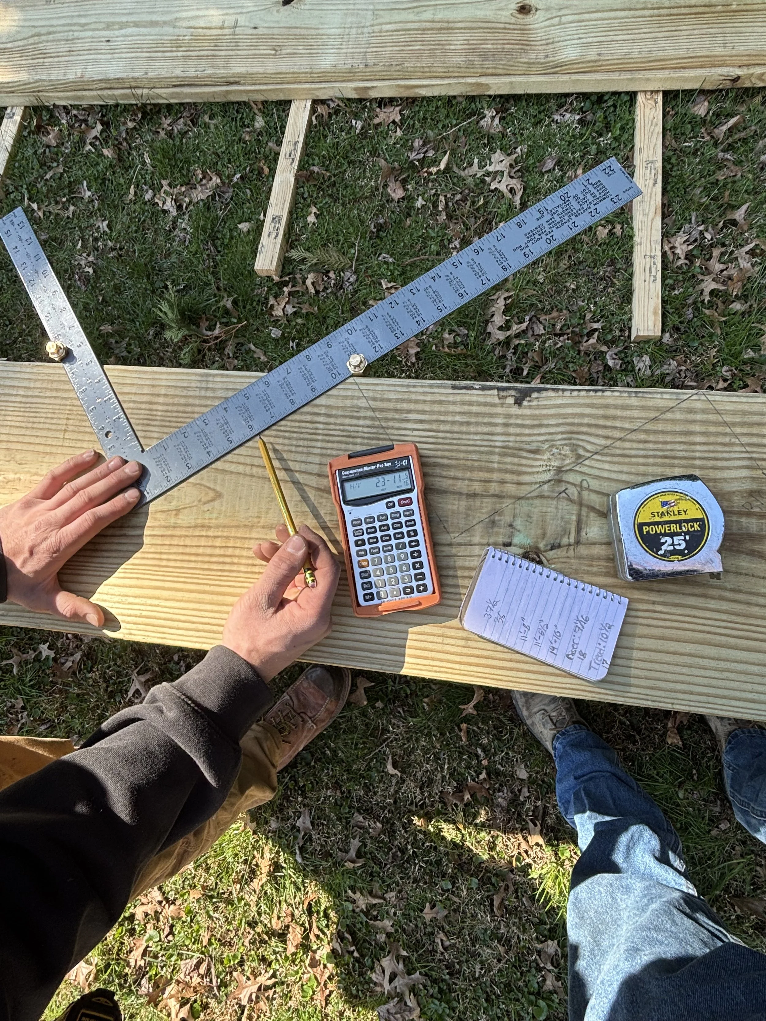 True North Builders making precise calculations on a piece of wood using a speed square