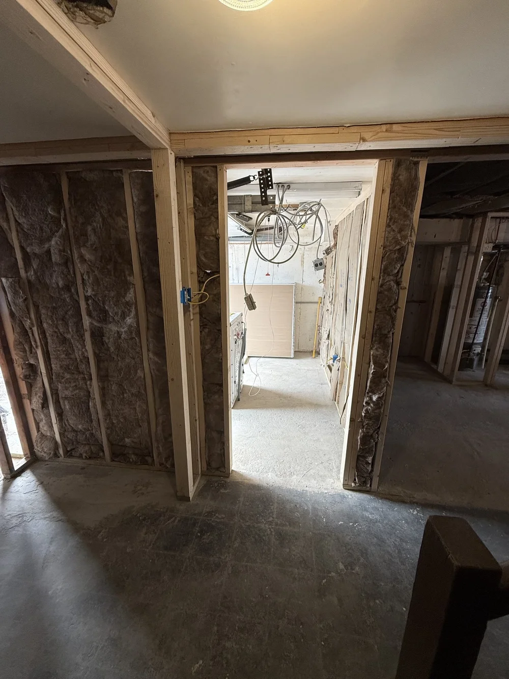 Basement insulation installed between studs before drywall