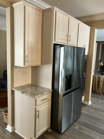 Custom-color cabinets surrounding a refrigerator