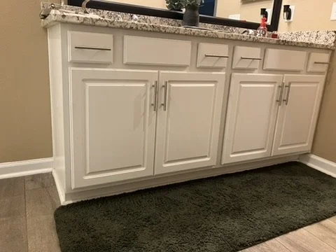 Before refinishing — the original white vanity cabinets