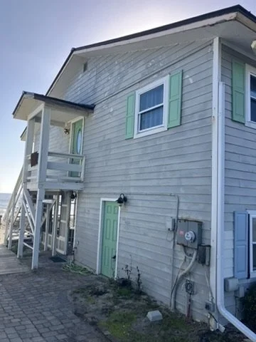 Before painting — original siding, door and stair elevation