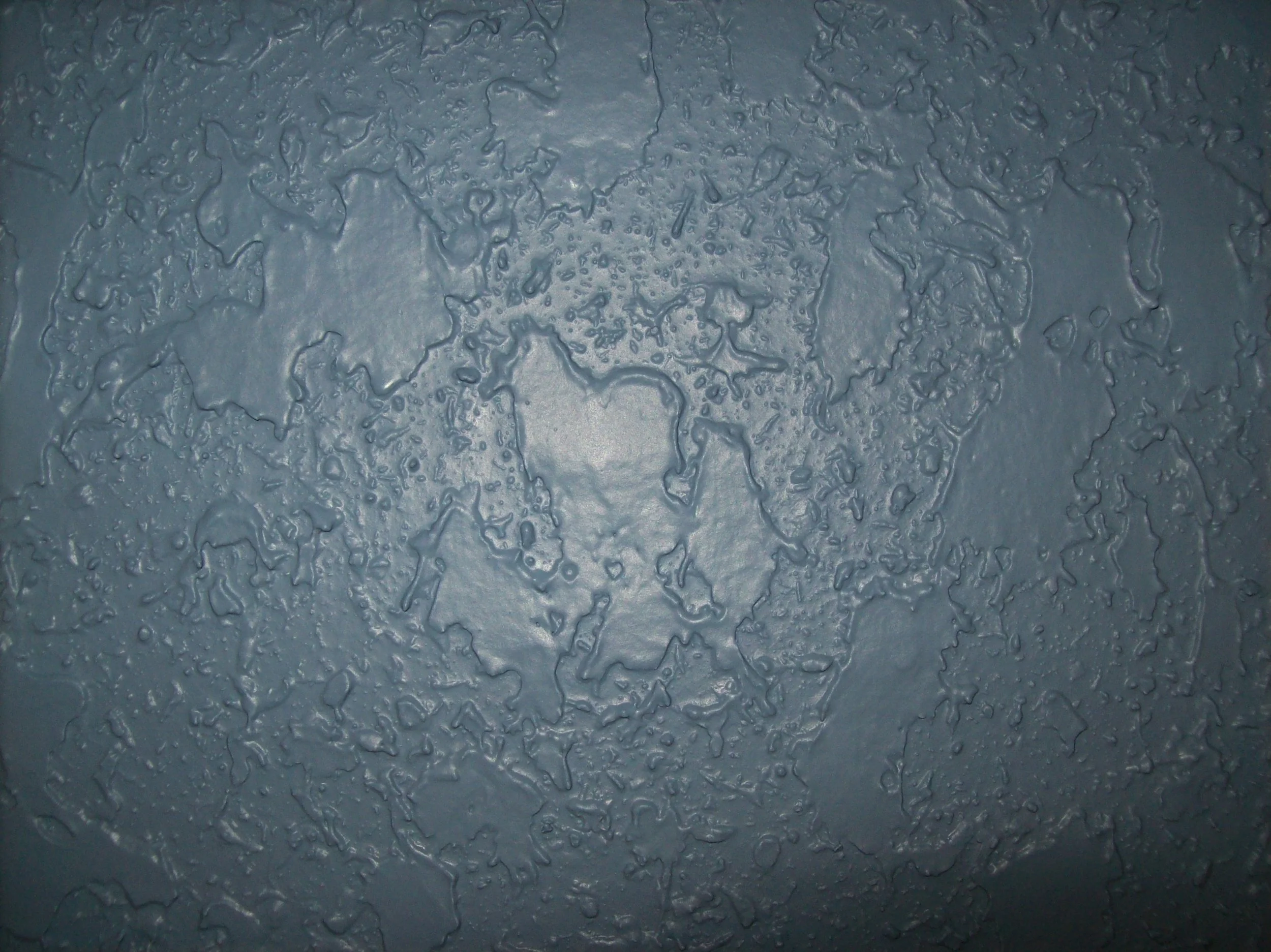 Close-up showing the flattened, irregular pattern of knockdown wall texture