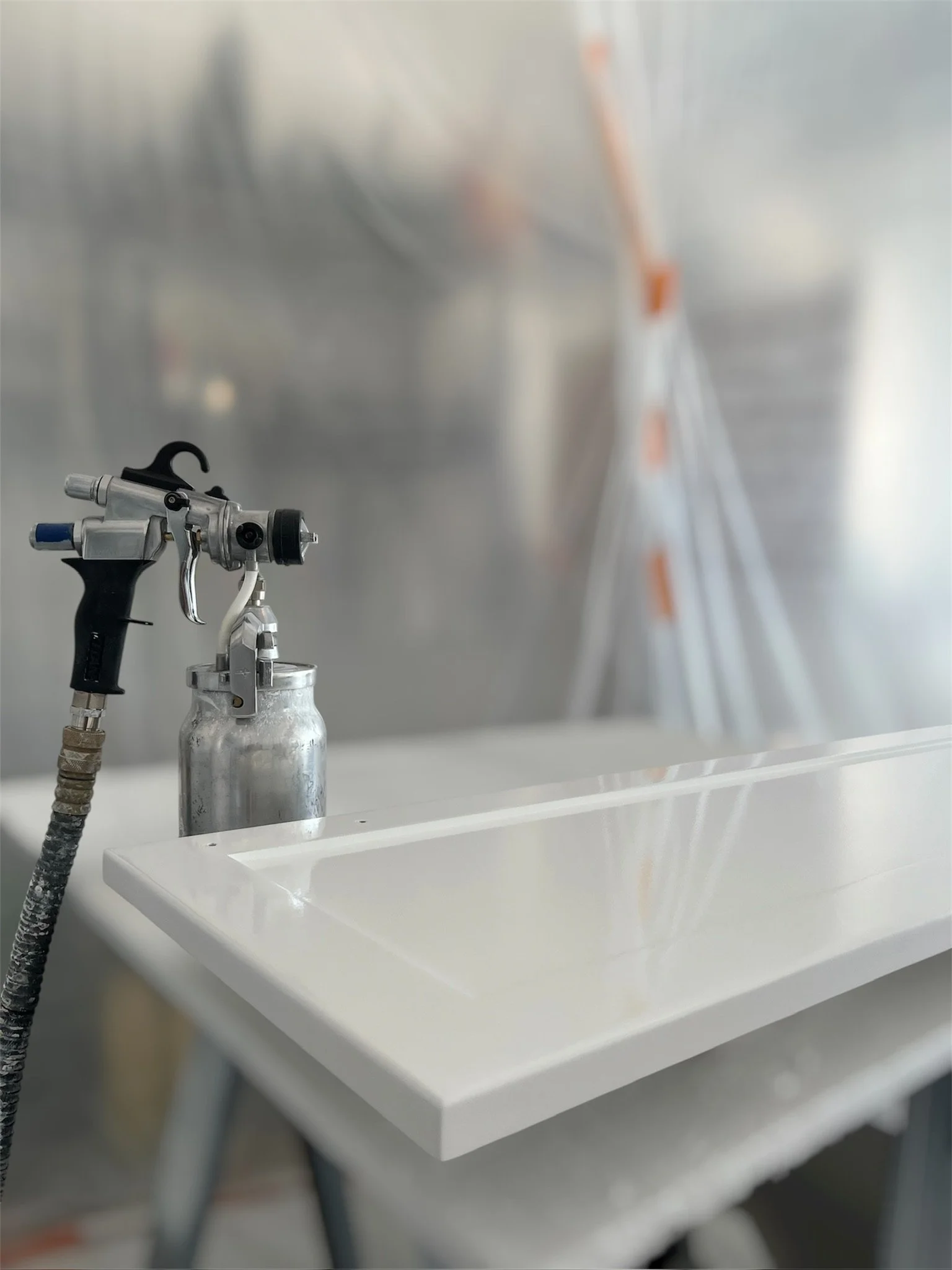Freshly sprayed white cabinet door with a smooth finish in the KSG workshop