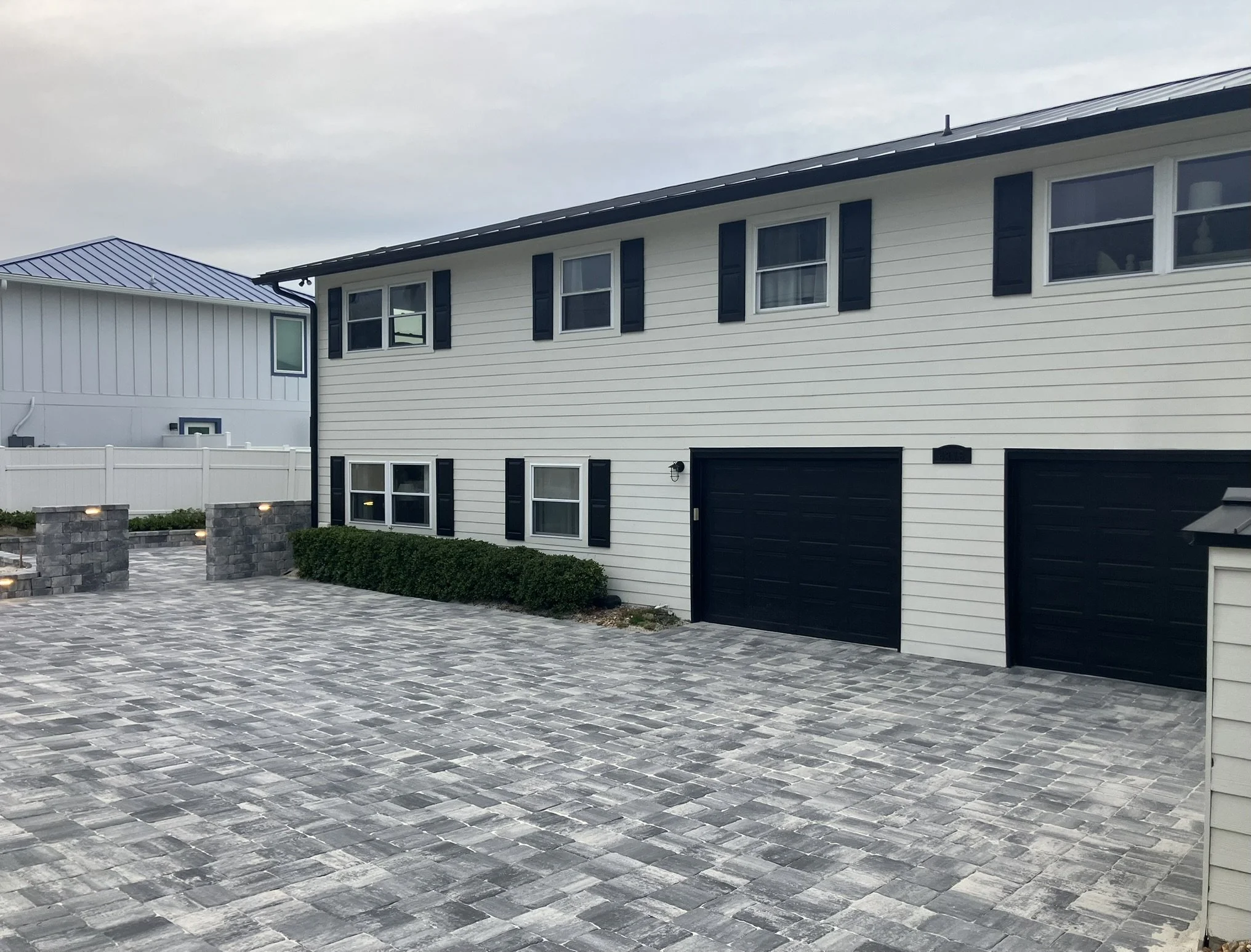 Coastal home front elevation with dark garage doors