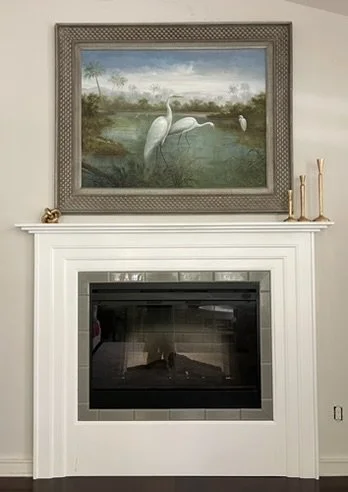 Finished white fireplace surround and mantel installed around the fireplace