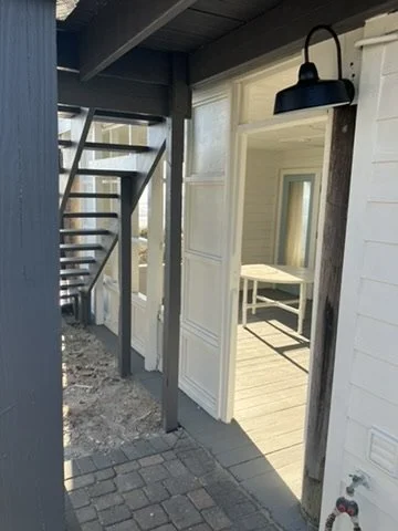 After painting — light entry trim beside the dark exterior staircase