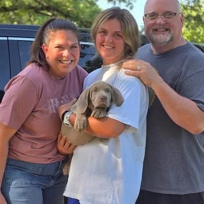 A family with their newly adopted puppy in the park