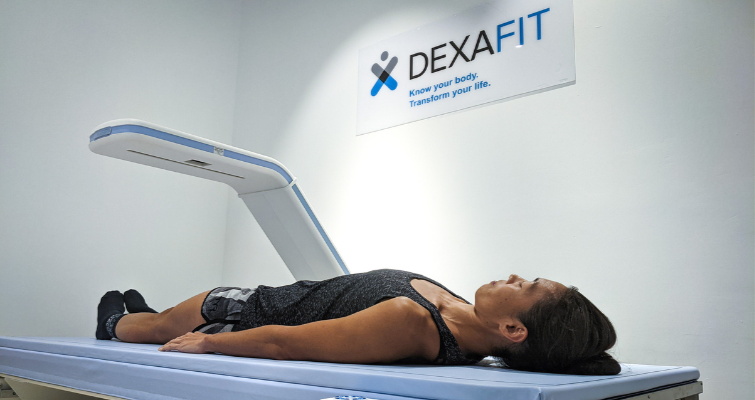 Person on DEXA body composition scanner with live stats
