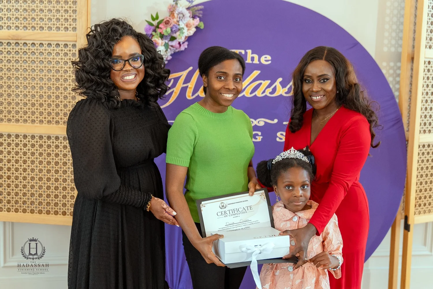 A participant holding a certificate alongside adults and a younger child