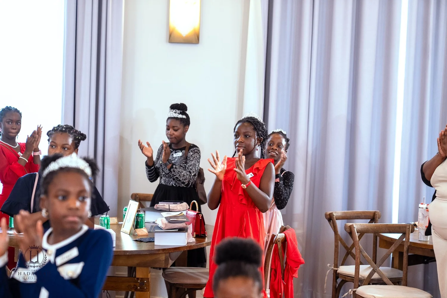 Participants standing and joining in an activity around the tables