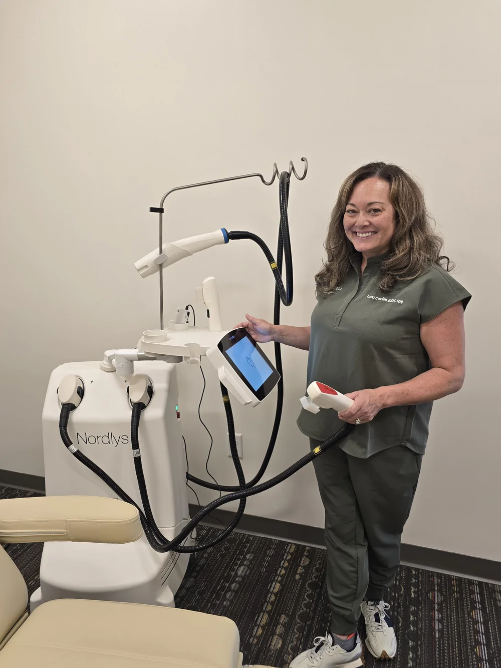 SkanWell team member demonstrating equipment beside a treatment chair