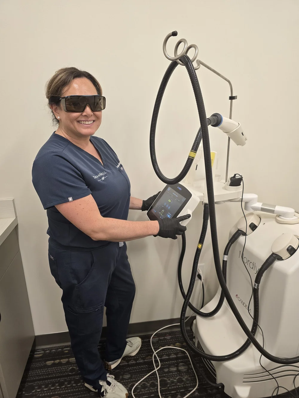 SkanWell team member standing beside treatment equipment in the clinic