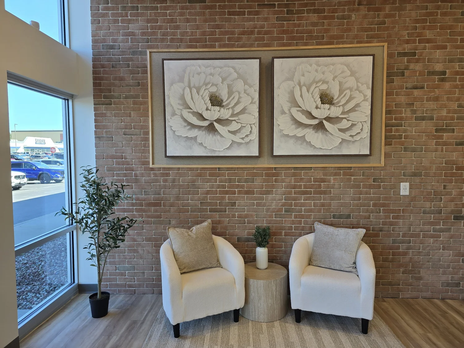 Two lounge chairs beneath botanical artwork in the SkanWell reception area