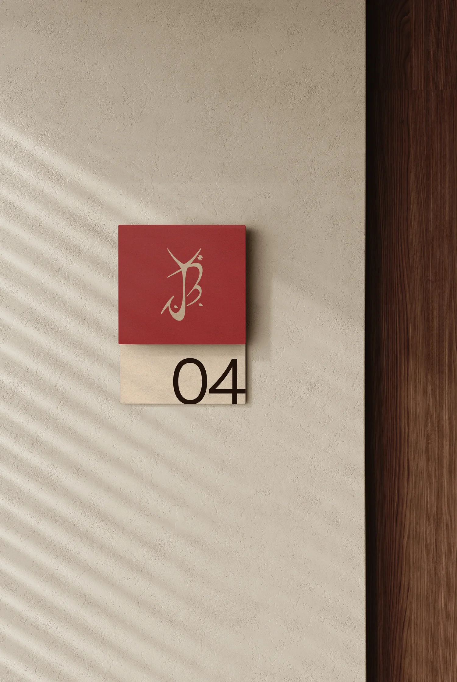 YBJ — wall signage in Henné and Sable on a natural plaster wall, room 04 at Chez LAJWAD, architectural application of the logo, mockup by StudioKus