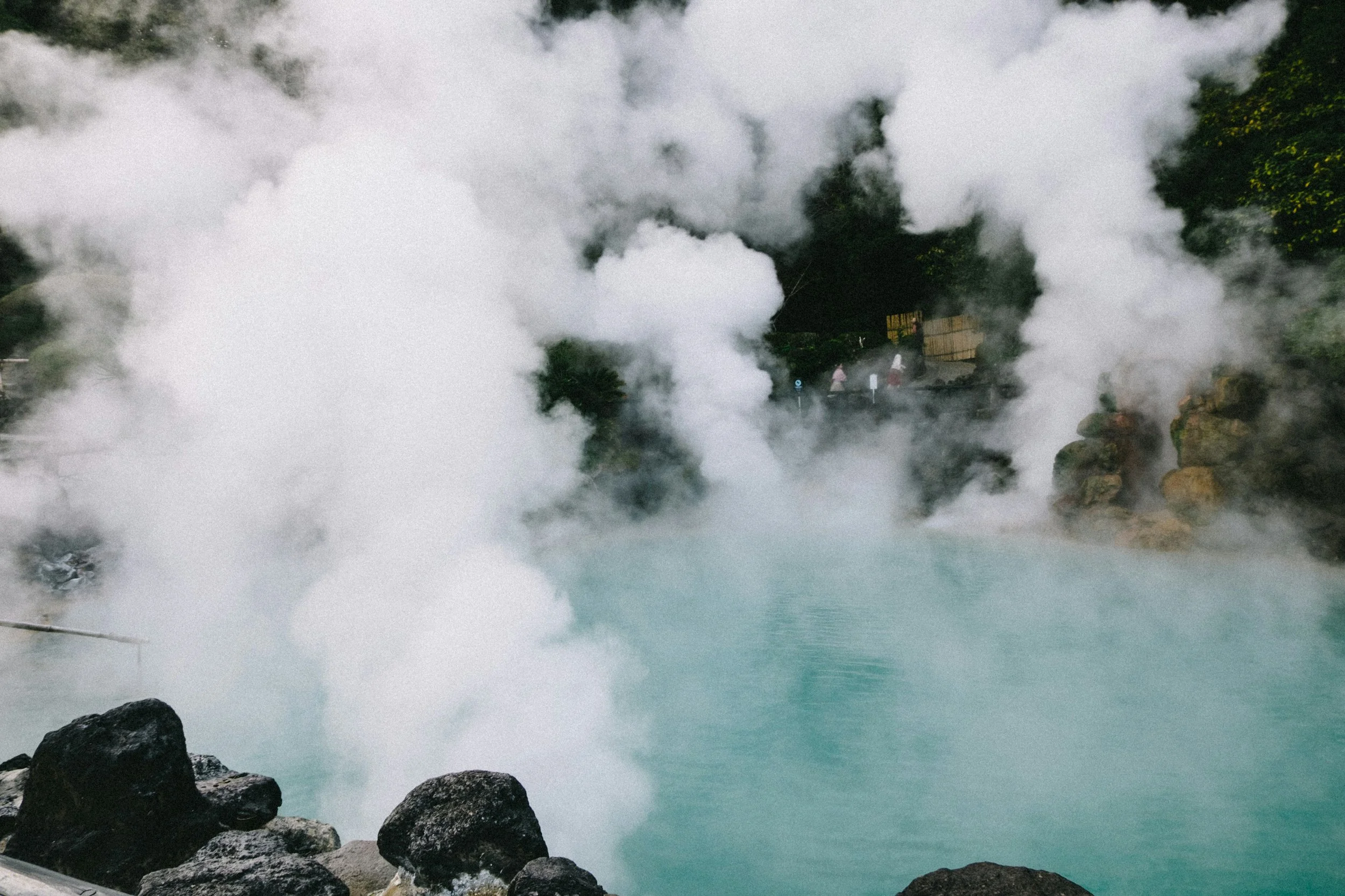 Private outdoor rotenburo hot spring bath at a Hakone ryokan,
         steam rising at dawn over a mountain valley