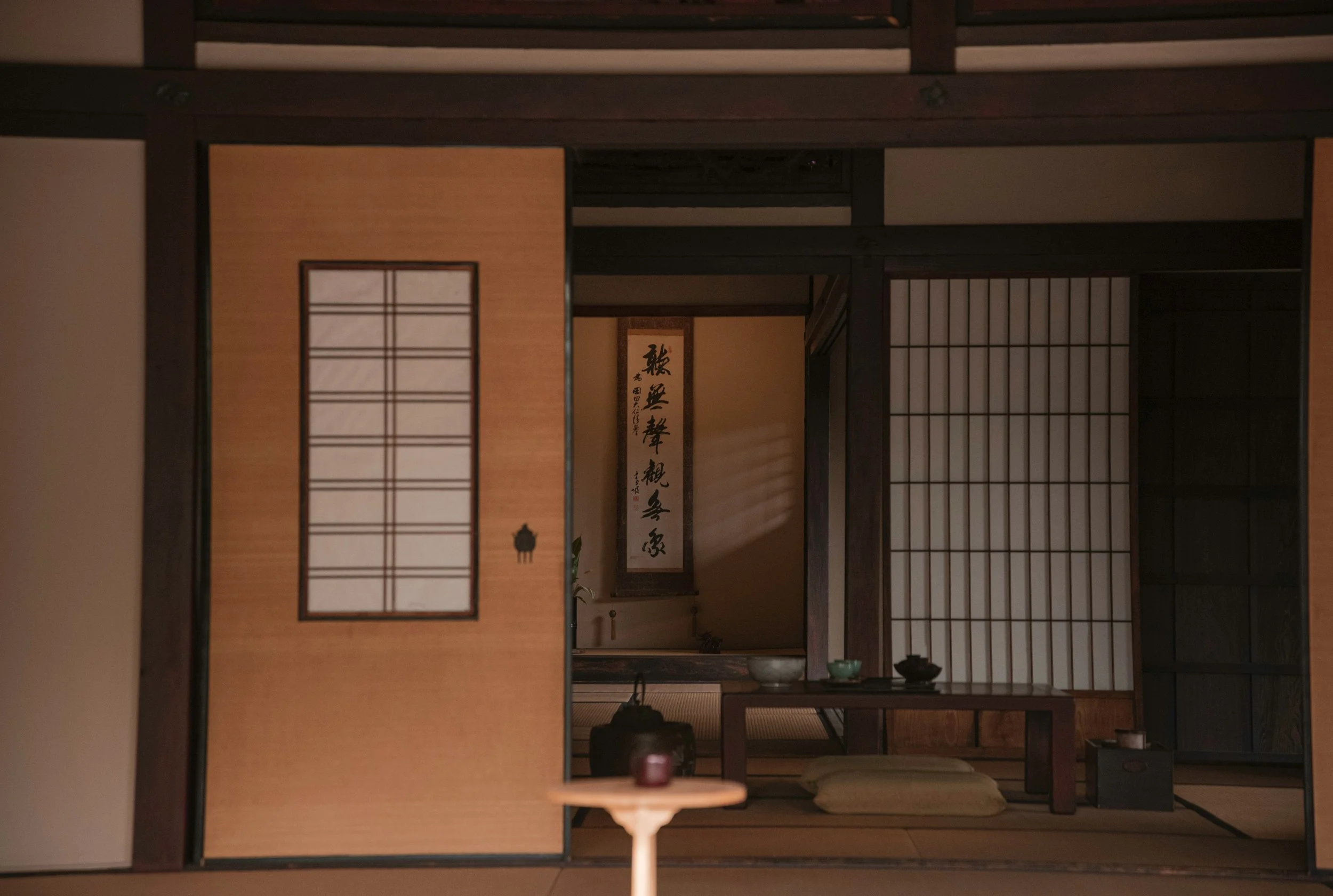 Interior of a traditional machiya townhouse in Kyoto, tatami
         floor, low wooden furniture, paper shoji screen, garden view